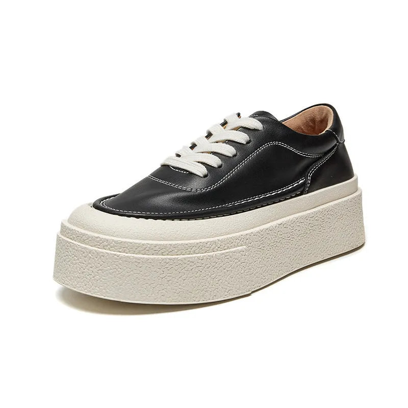 Women's black embossed leather platform sports shoes with round toe and white rubber sole on a white background.