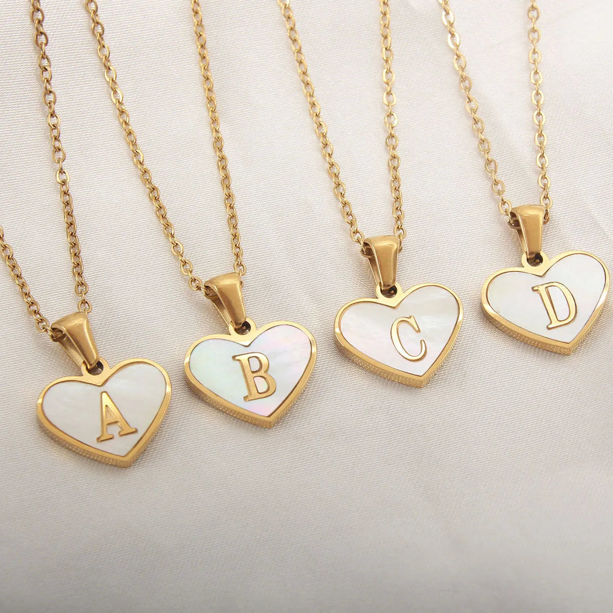Gold-plated heart necklace with white shell centre on an adjustable stainless steel chain.