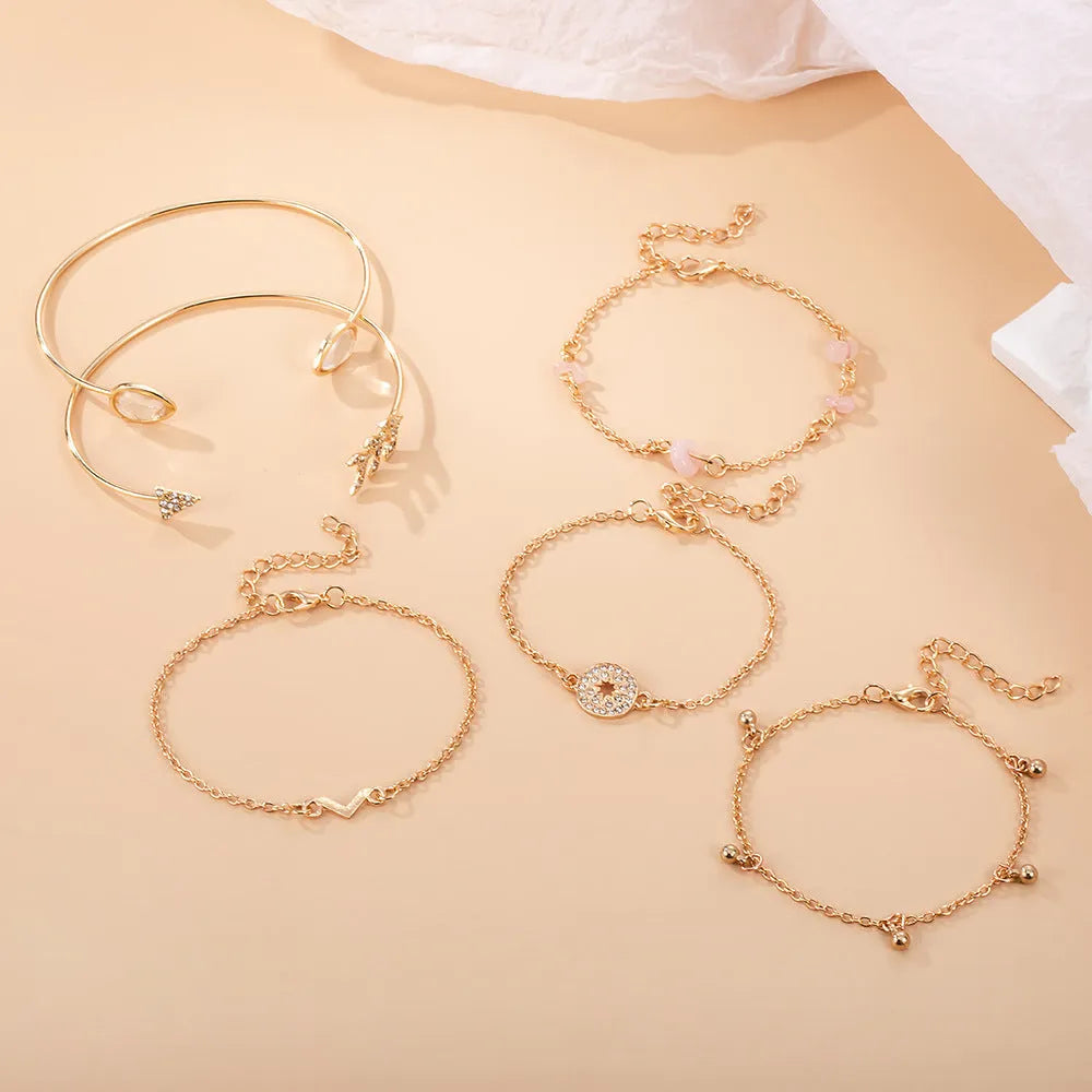 Gold six-piece bracelet charm set with V-shaped, arrow, water drop, and spot drill designs on zinc alloy
