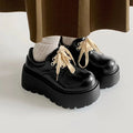 Women's matte black retro lace-up shoes with thick rubber sole and block heel.