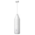 A handheld electric milk frother with a stainless steel wand and a plastic body, shown in black, white, and khaki colour options.