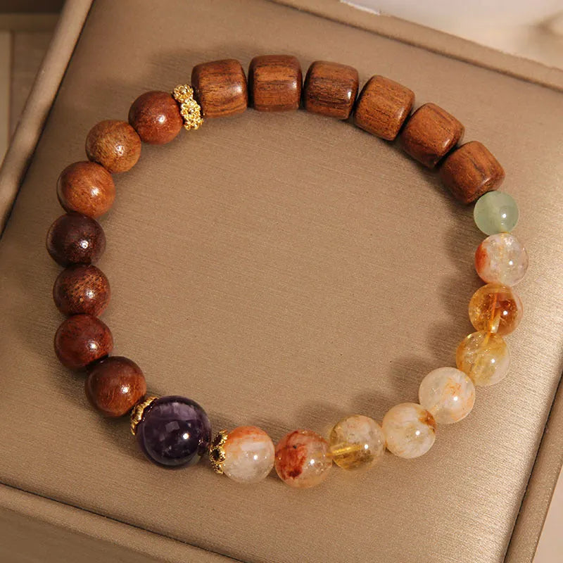 Yellow tower crystal, ebony, and amethyst bead bracelet with pearl and rhinestone details.