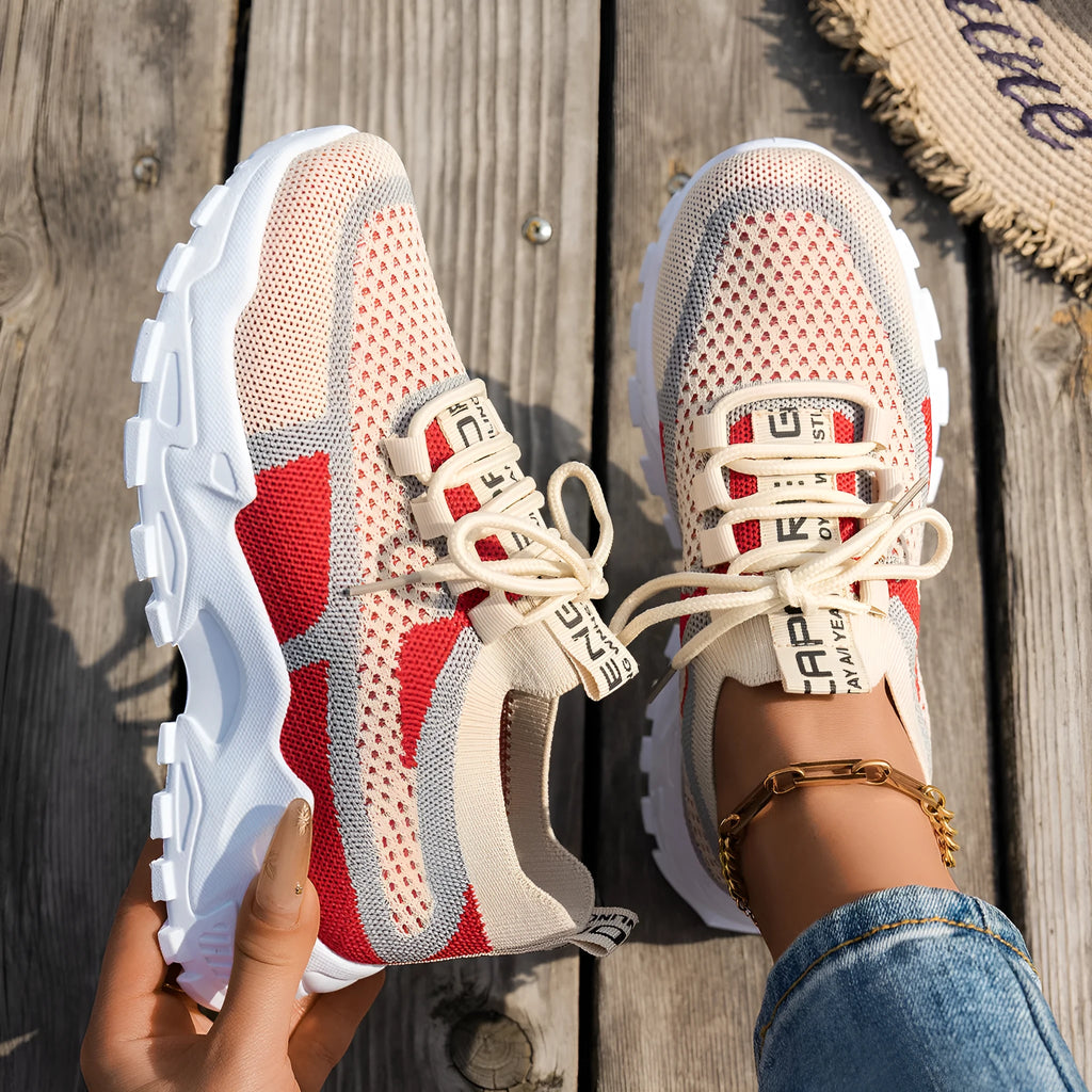 Women's Flyknit mesh lace-up sneakers in a grey colourway, showing the breathable upper and rubber sole.