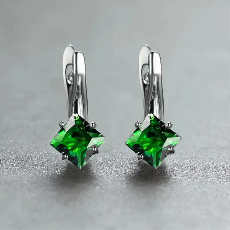 A pair of copper diamond design earrings for women with inlaid zircon stones, shown in blue, green, and a metallic colour.