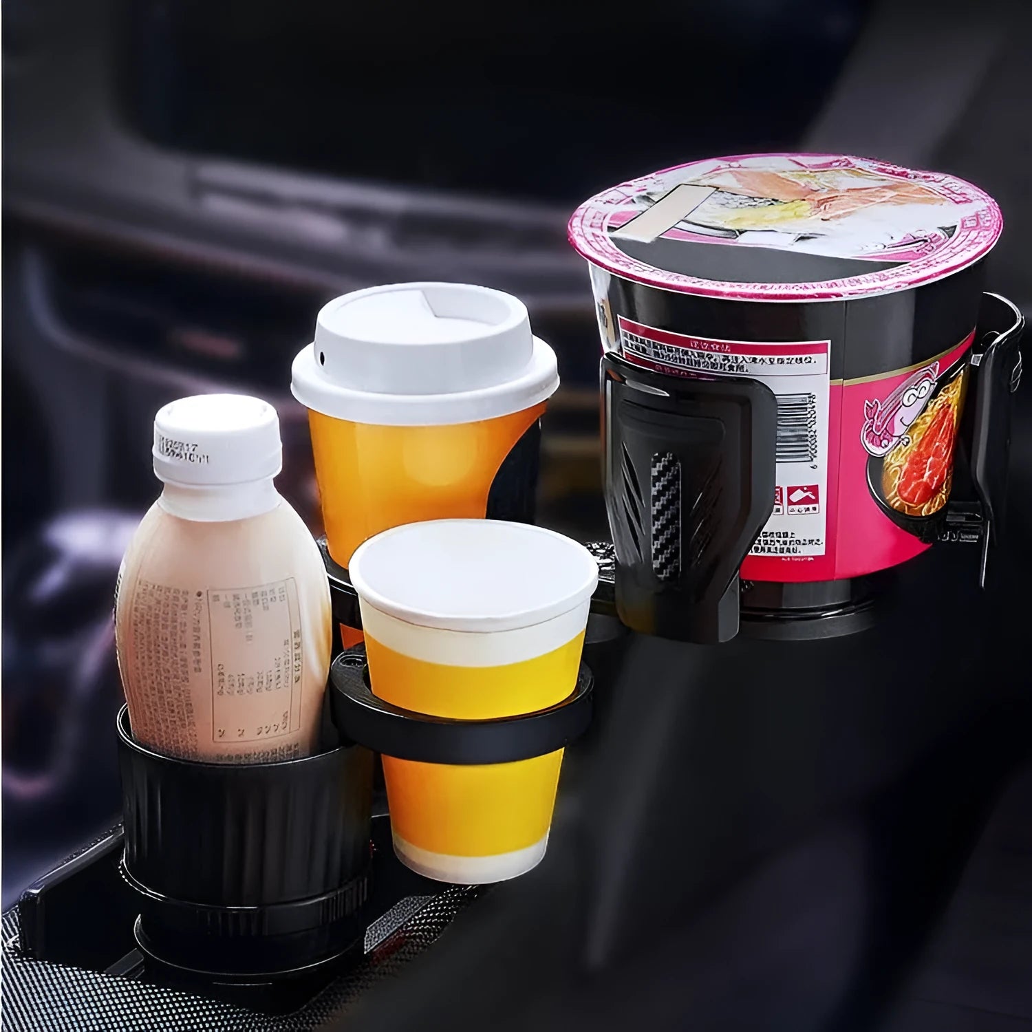 Retractable black car drink holder with adjustable base on a car dashboard.