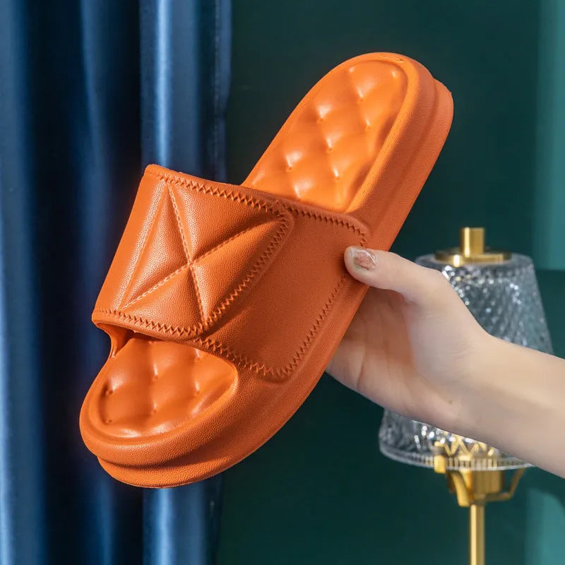 A pair of thick-sole EVA bathroom slippers in a choice of five colours, shown on a bathroom floor.