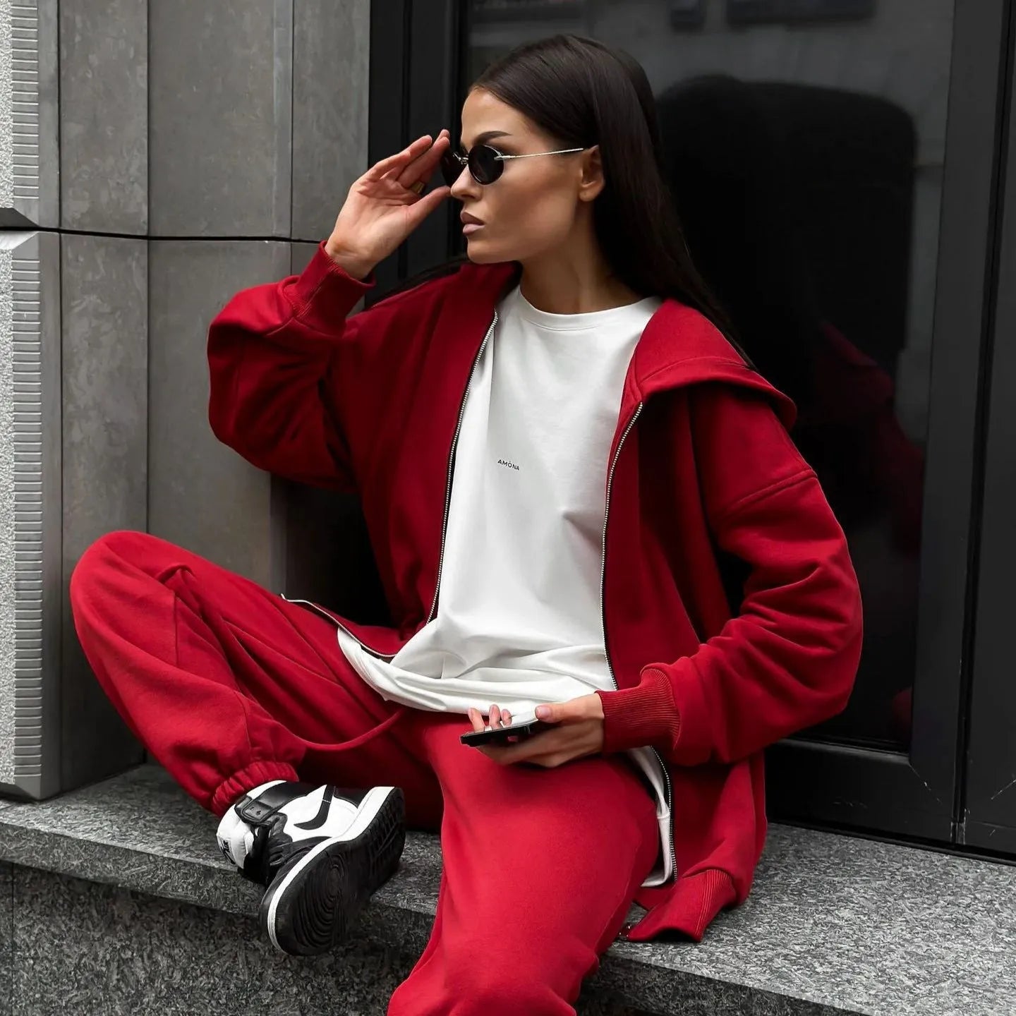Red loose fit two-piece suit comprising a long-sleeved coat and trousers on a rack.