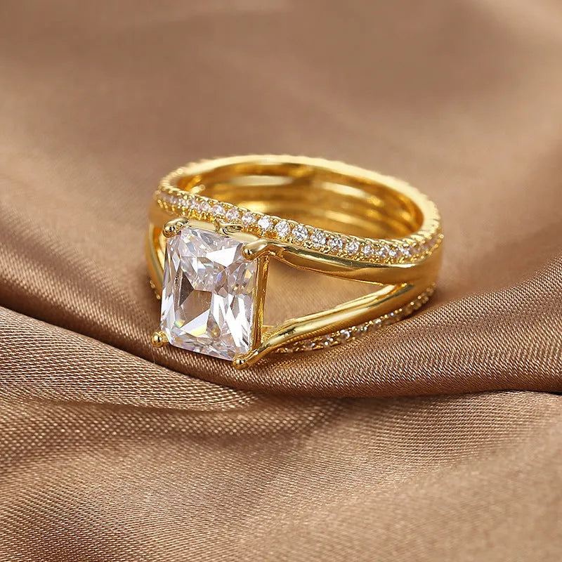 Geometric gold-coloured women's ring with a square zircon stone, shown in size options 6 to 9.
