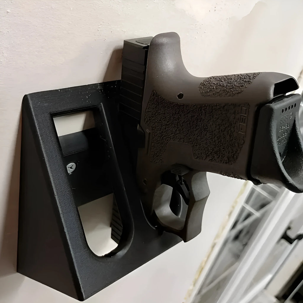 Matte black plastic pistol display stand with a punk-style design on a flat surface.
