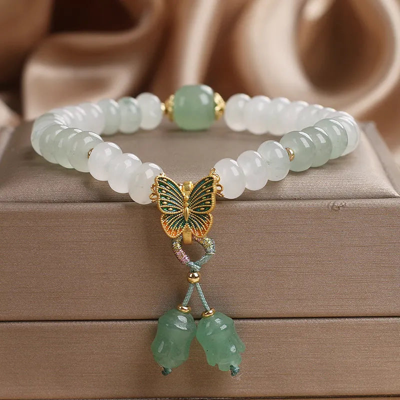 Green crystal abacus bead bracelet with butterfly charm and tassel detail, 17 cm length