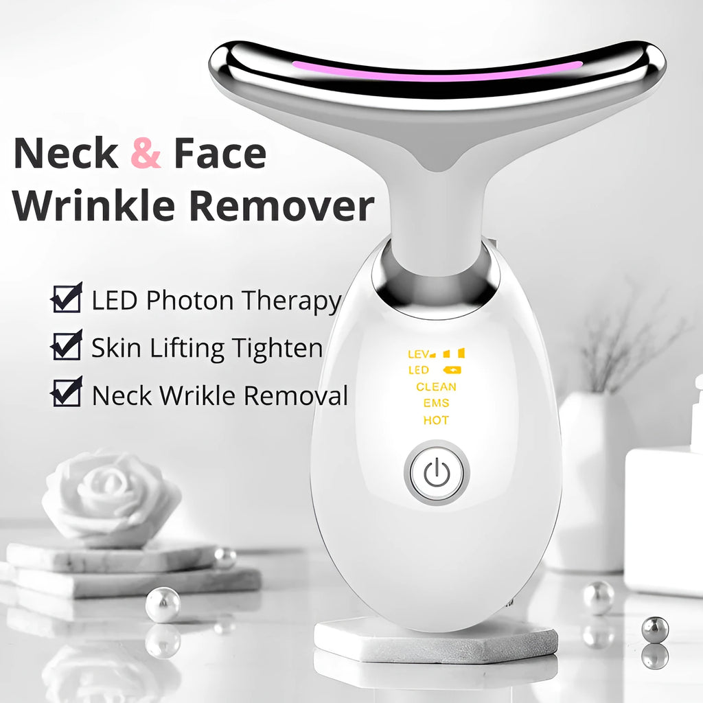 White EMS thermal neck massager device with LED lights on a stand next to USB cable and moisturiser.
