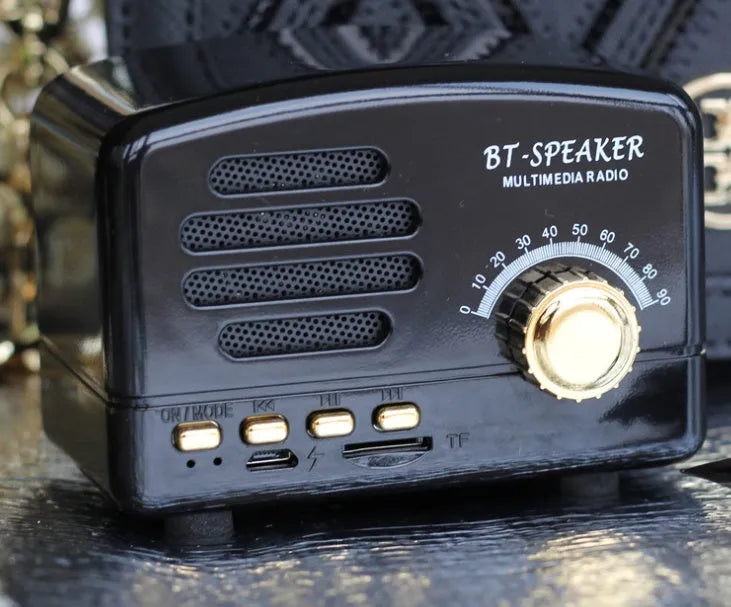 Vintage wood effect Bluetooth speaker in pink, black and wood grain colours showing compact size