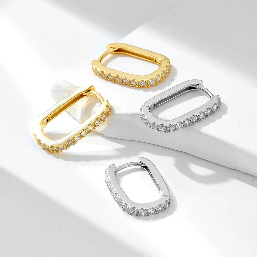 S925 sterling silver oval zircon ear clips on ear, shown in yellow and white colour options.