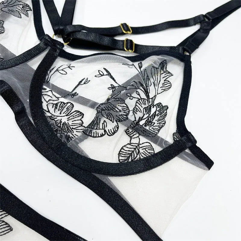 Black floral lace women's three-piece set with top, trousers, and waist cincher on a hanger.