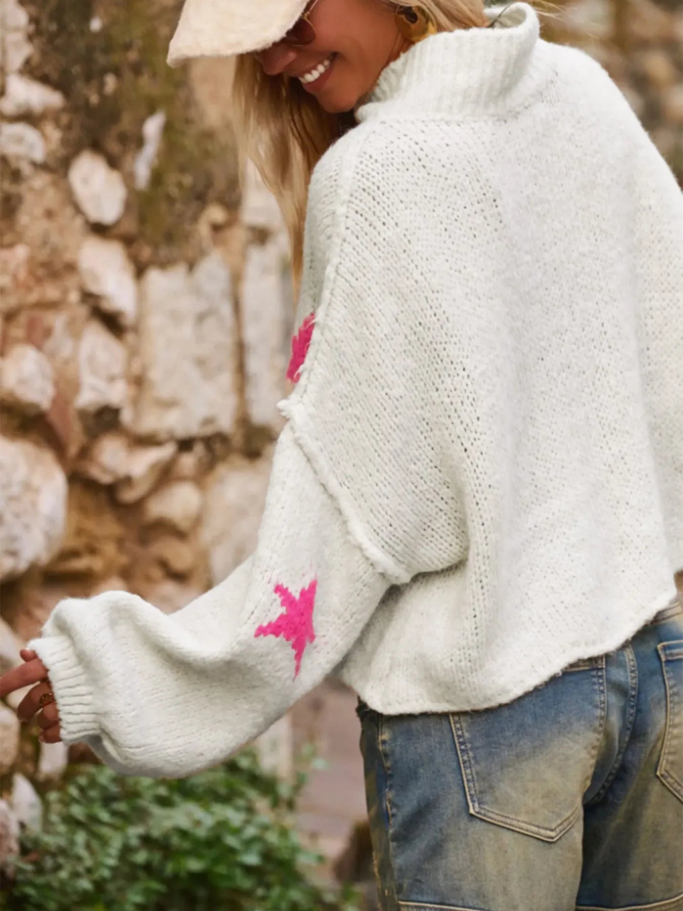 White women's loose fit turtleneck sweater with a black five-pointed star pattern on the front.
