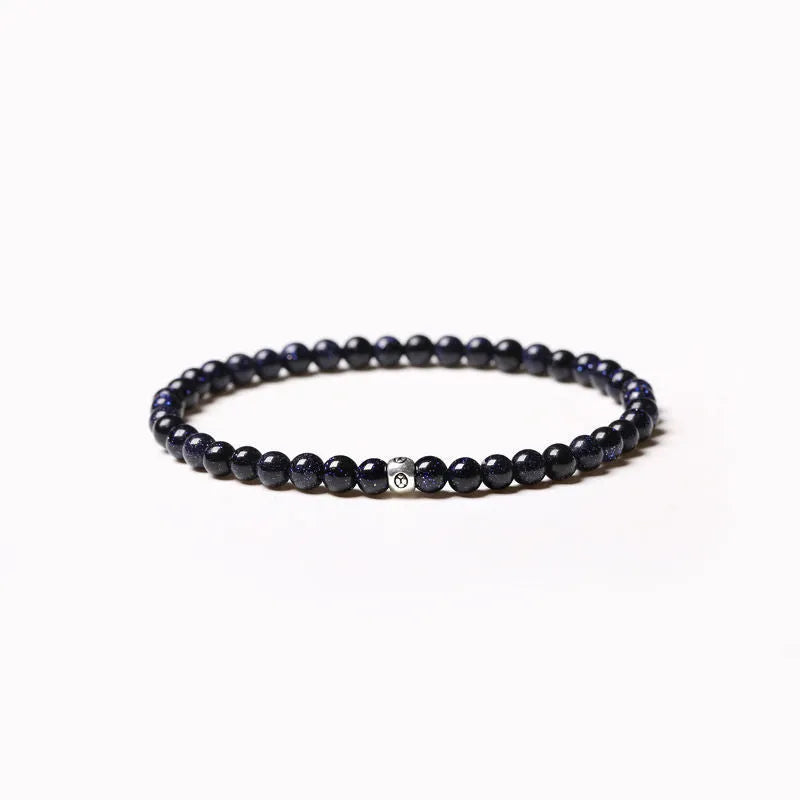 A unisex beaded bracelet with small 4mm obsidian, blue San, and black agate stones in geometric shapes.