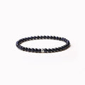 A unisex beaded bracelet with small 4mm obsidian, blue San, and black agate stones in geometric shapes.