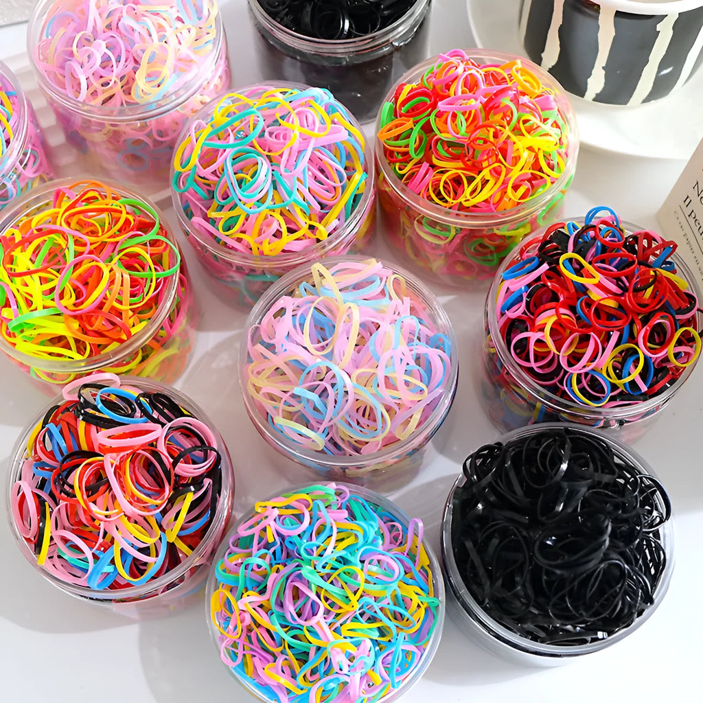 Multi-colour TPU baby hair elastic bands spilling from a reusable container.