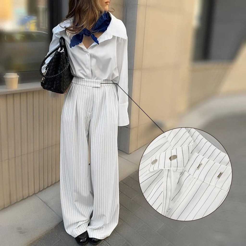 White striped wide-leg trousers with a front zip closure on a model.