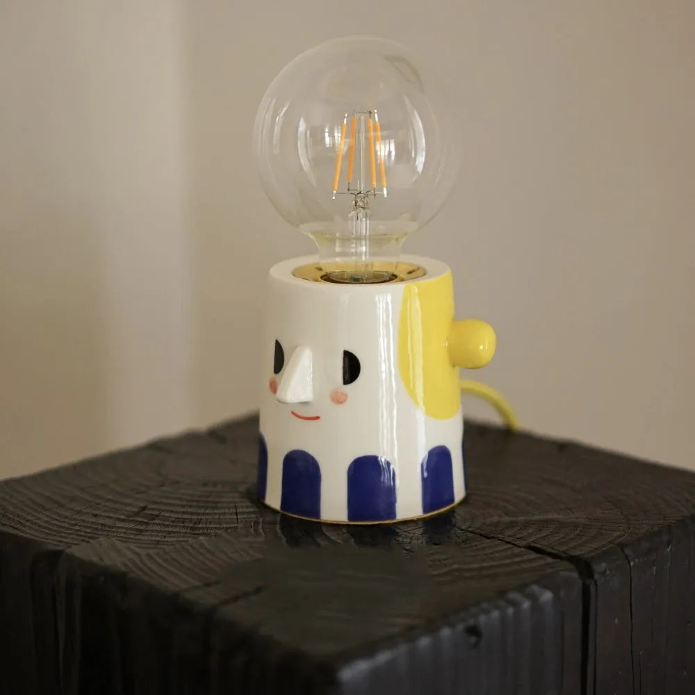 Handmade ceramic bedside lamp with ball headlight design on wooden surface