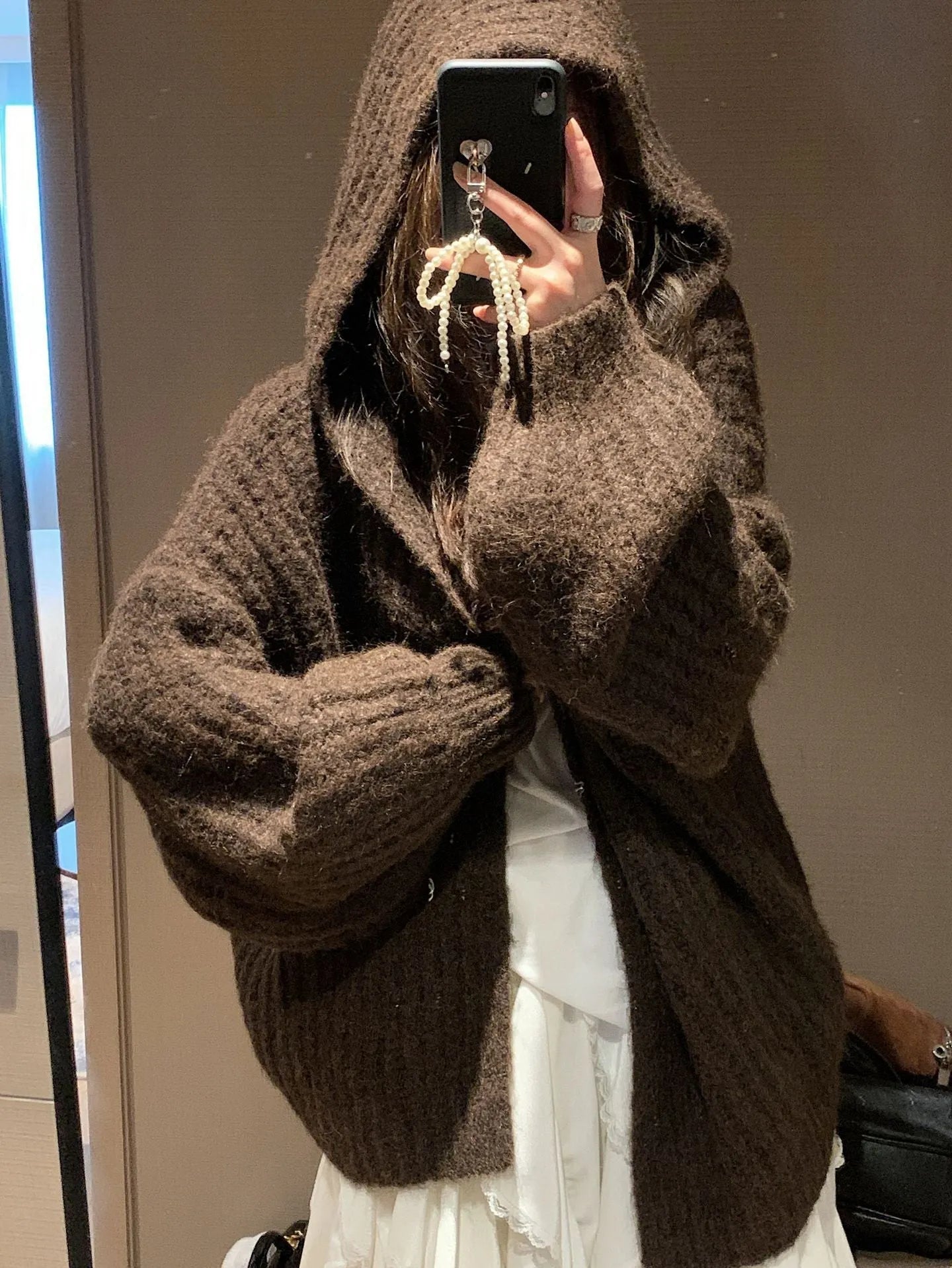 Brown loose-fit hooded cardigan sweater for women on a hanger