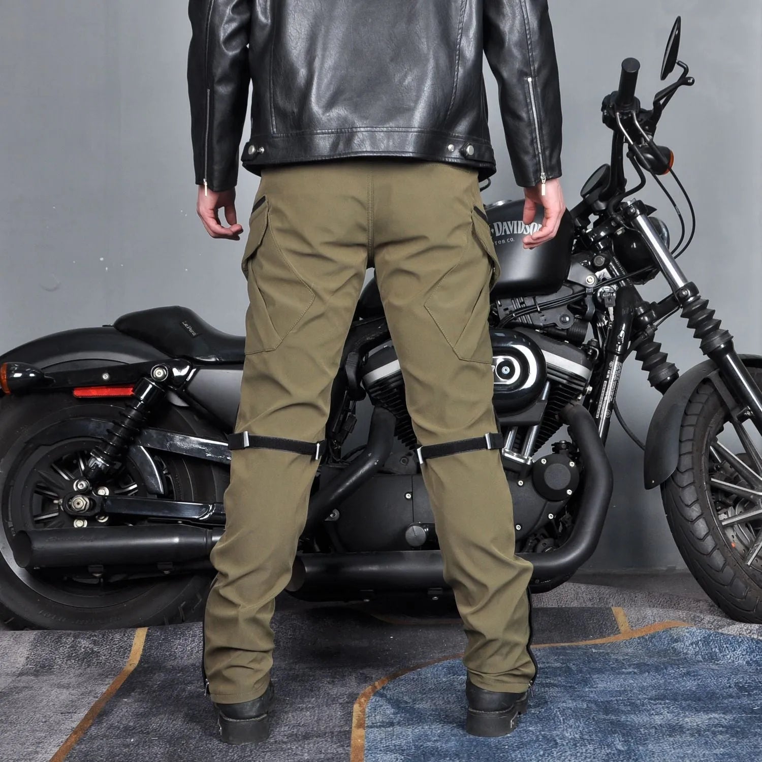 Man's black waterproof motorcycle cycling pants with adjustable belt laid flat.