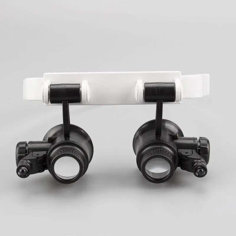 White head mounted magnifying glass with illuminated loupe for clock and electronic repair work.