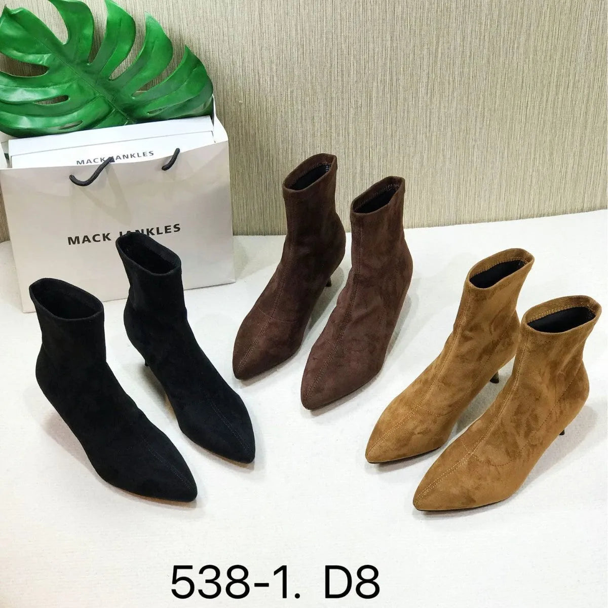 Black women's pointed toe Martin ankle boots with a high stiletto heel on a model.