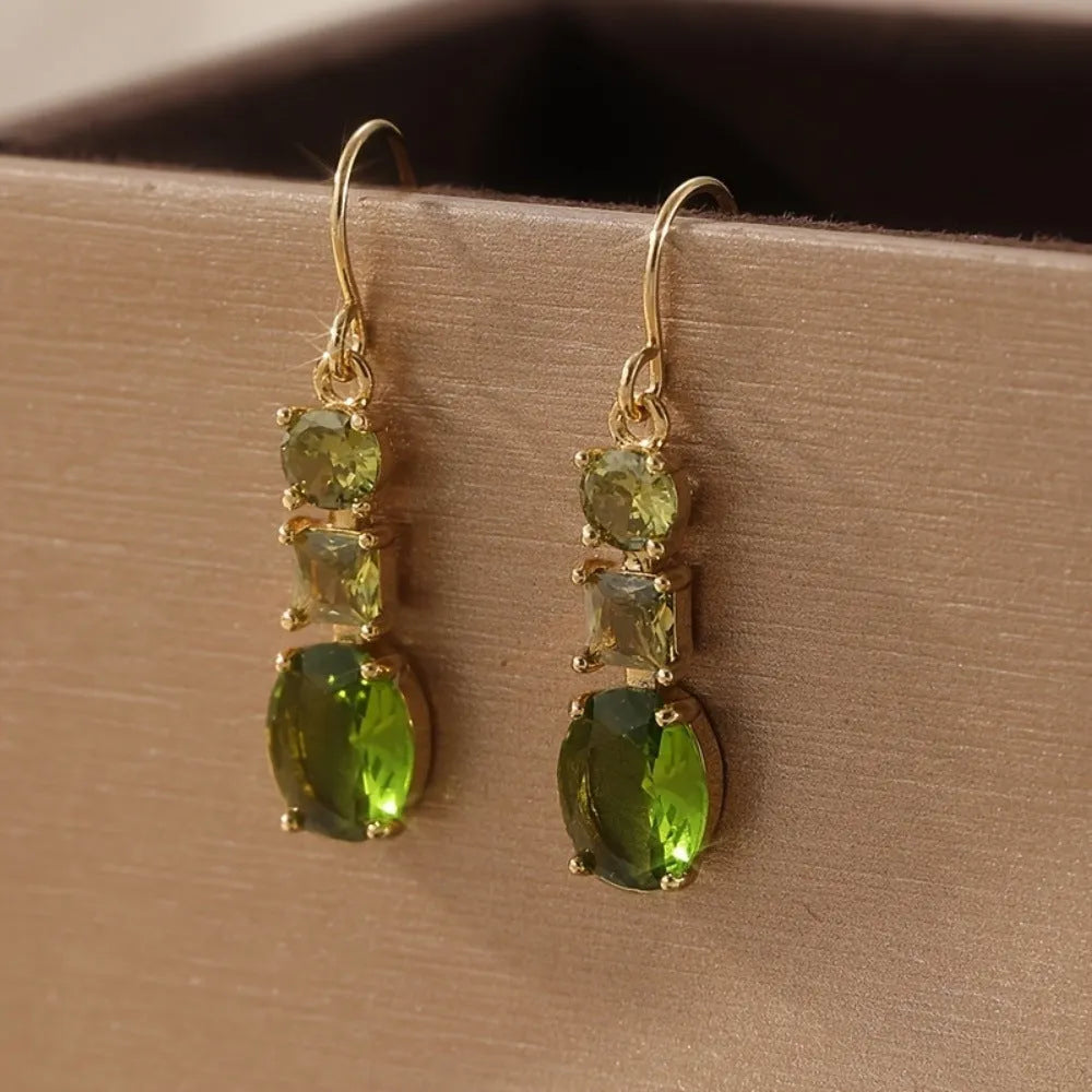 A pair of green geometric quadrilateral earrings made from copper, showing a simple retro bohemian style.