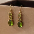 A pair of green geometric quadrilateral earrings made from copper, showing a simple retro bohemian style.