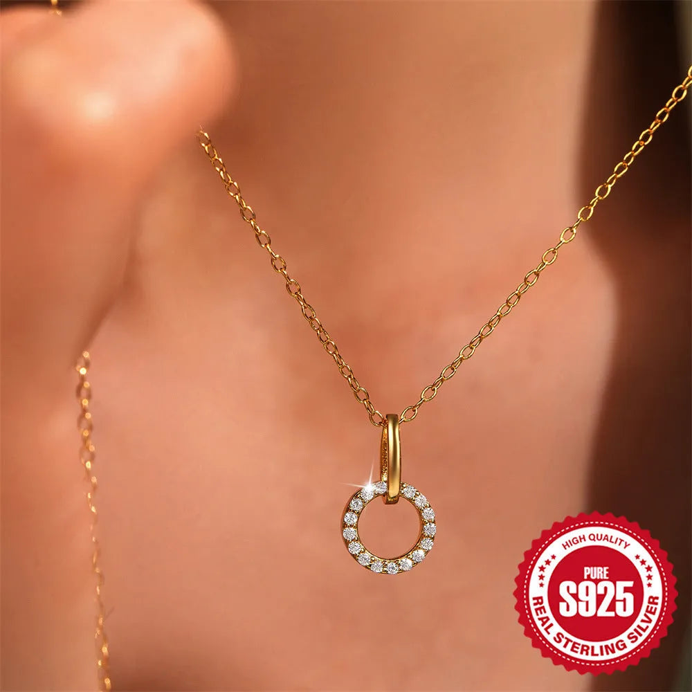 Gold-coloured sterling silver adjustable clavicle chain with interlocking geometric zircon pendant.