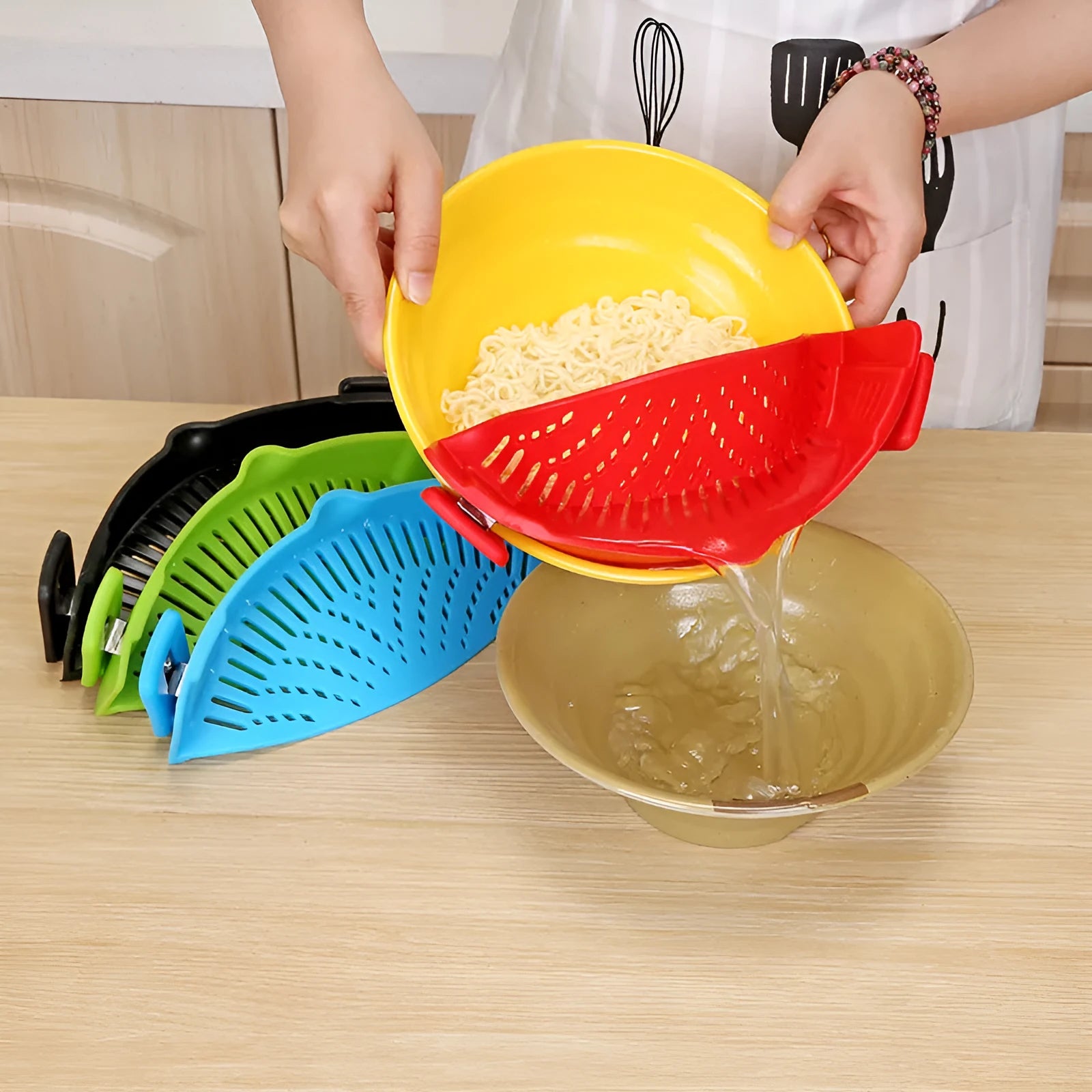 Silicone clip-on kitchen strainer attached to pot rim draining liquid