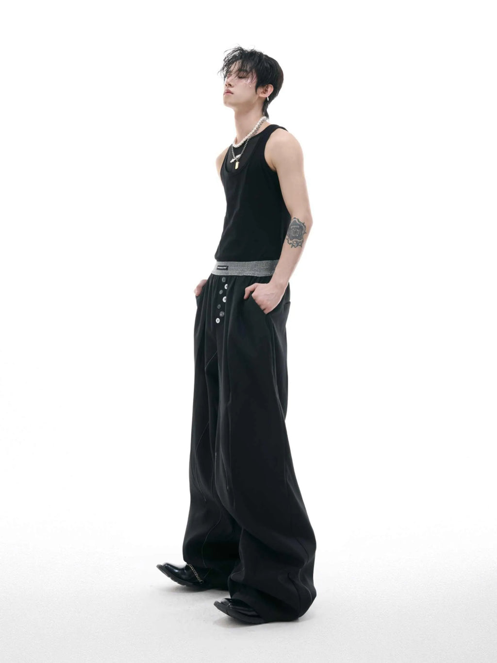 Drooping straight suit pants in black and grey colours showing high waist and button open line design detail.