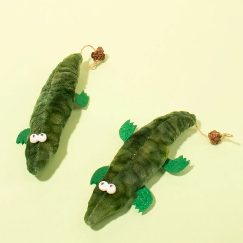 Green plush alligator cat toy with catnip filling and peppermint scent for oral cleansing.