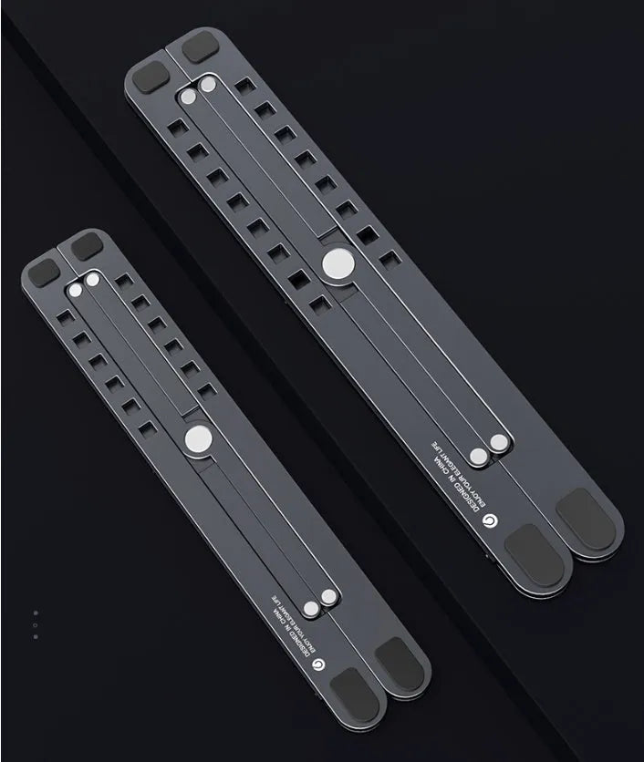 Aluminium foldable laptop stand in silver colour set to medium height with a laptop on top.