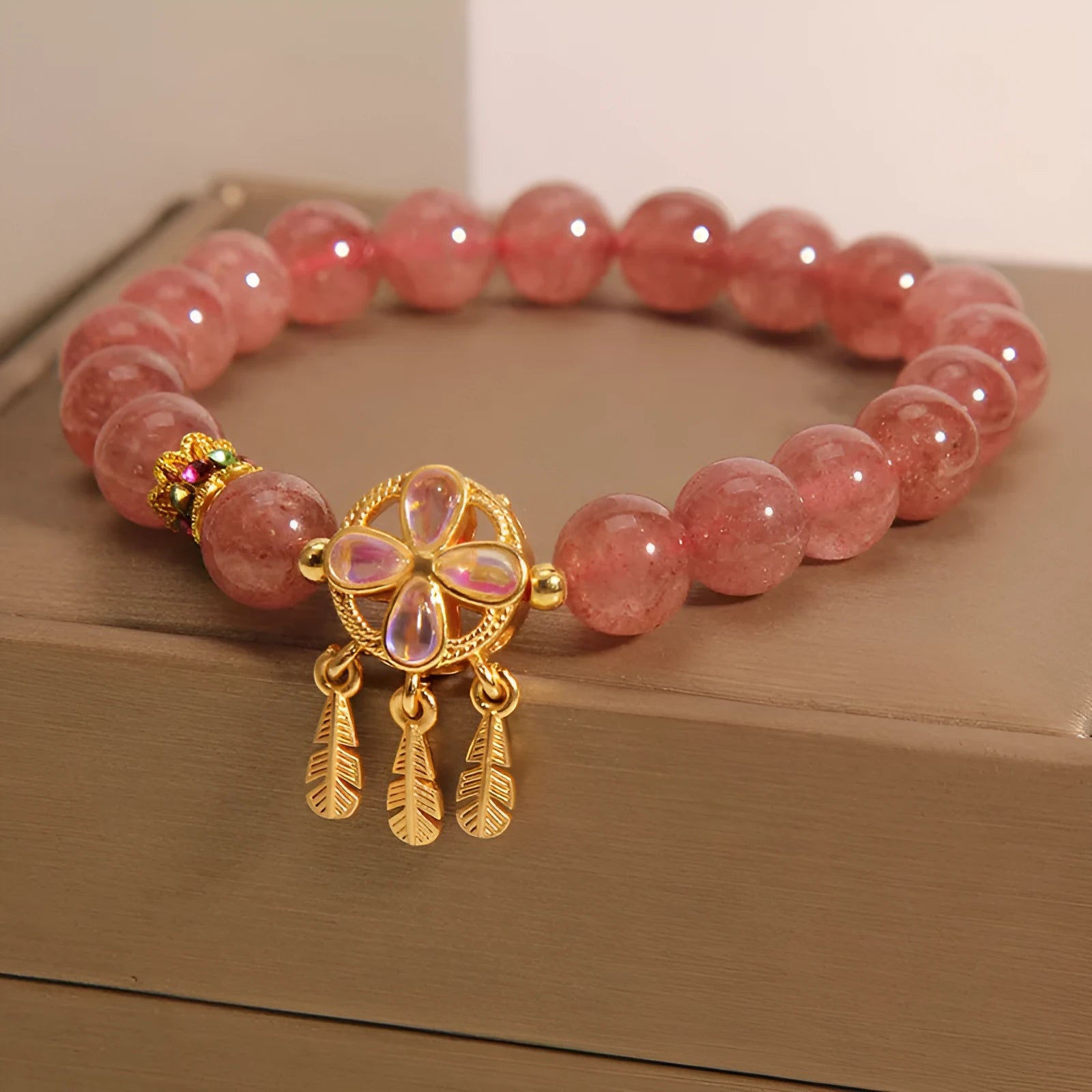 Natural strawberry quartz bracelet for women with a four-leaf dream catcher pendant on an adjustable chain.