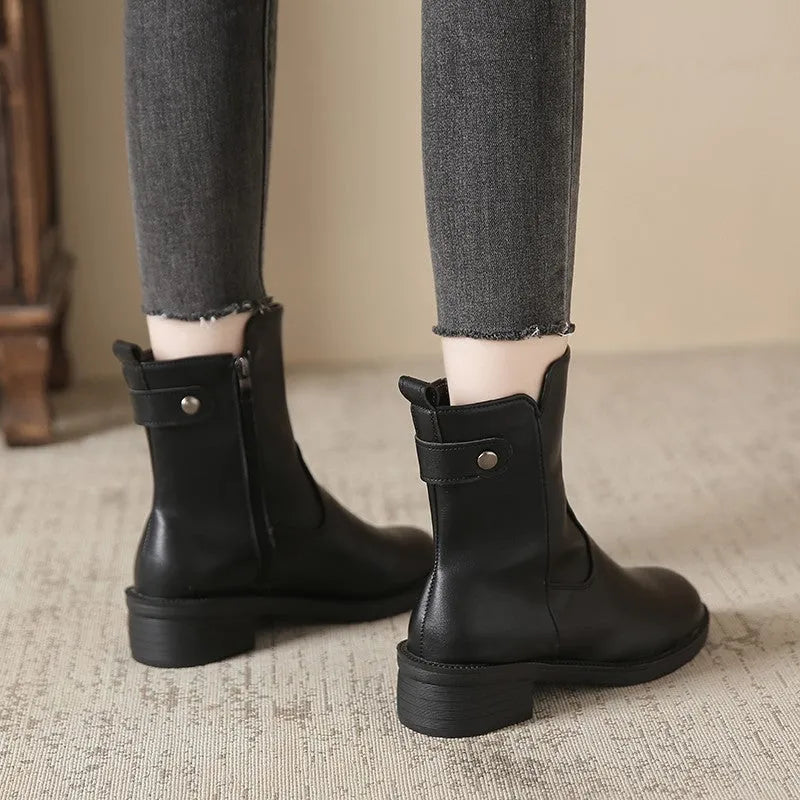 Black women's ankle boots with a side zip, round toe, and low rubber sole.