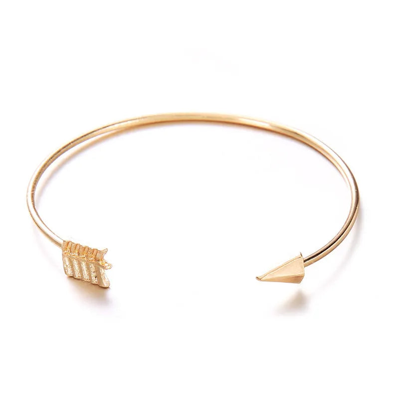 Gold electroplated vintage women's cuff bracelet with arrow and knotted design.