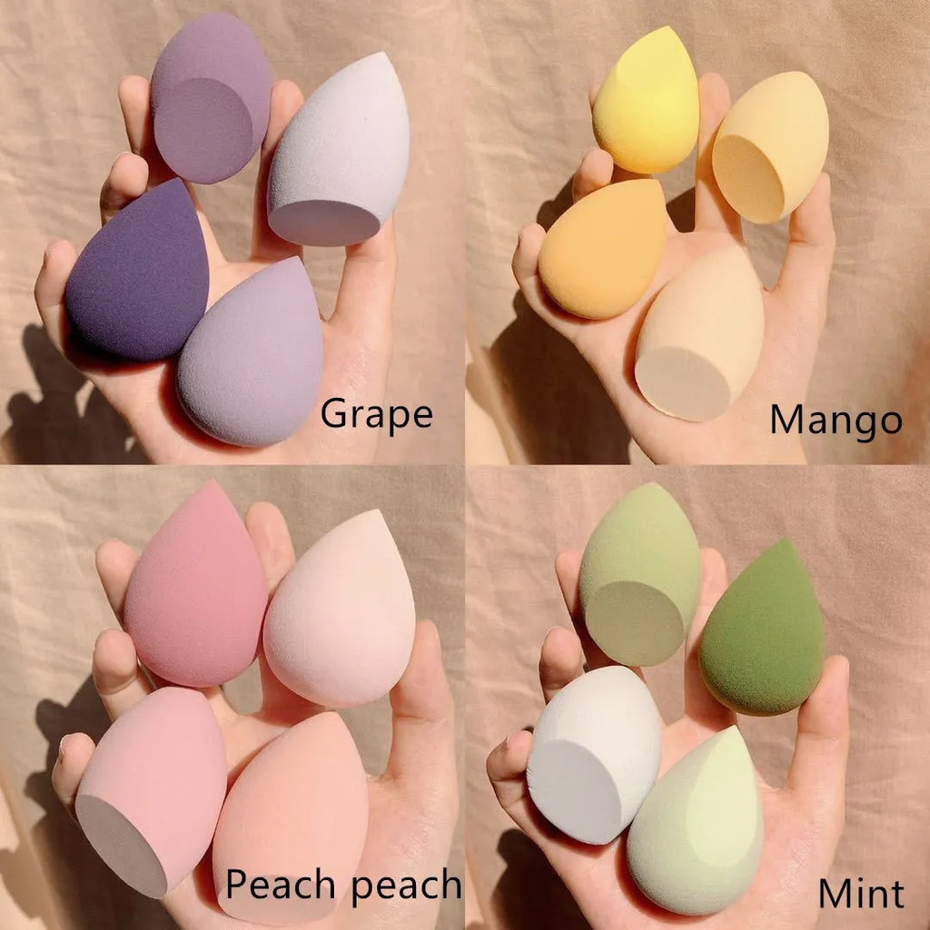Box containing four coloured makeup egg sponges in Grape, Mango, Mint, and Peach.