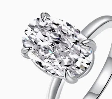 Oval ring with four-claw setting showing hand-cut gemstone in gold and silver colour options