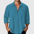 Man wearing a loose-fit, long-sleeve casual shirt with a stand collar, on a beach.