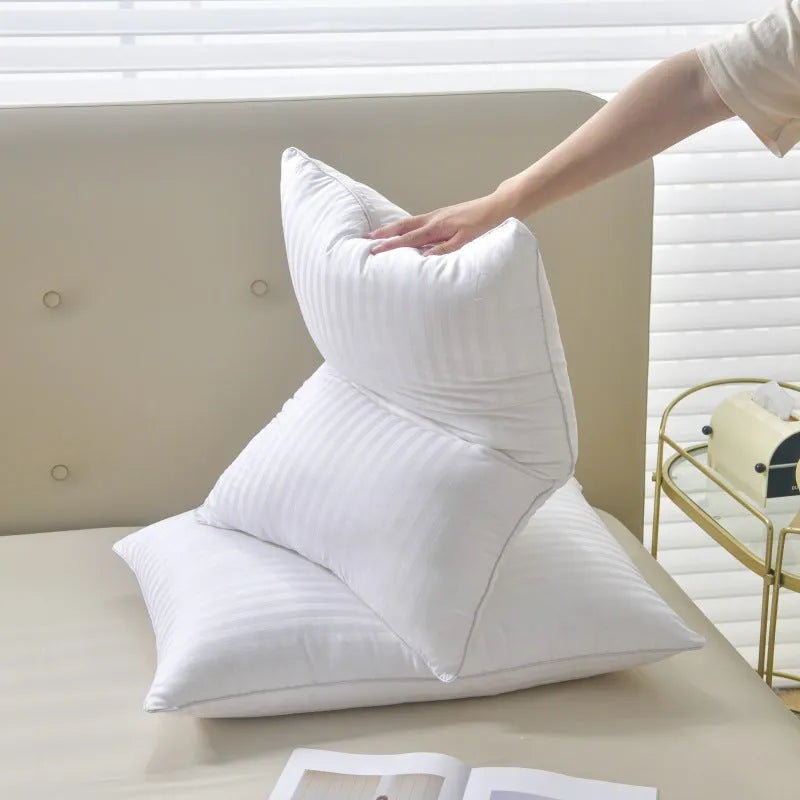 White cotton satin stripe feather pillow showing simple design on a bed.