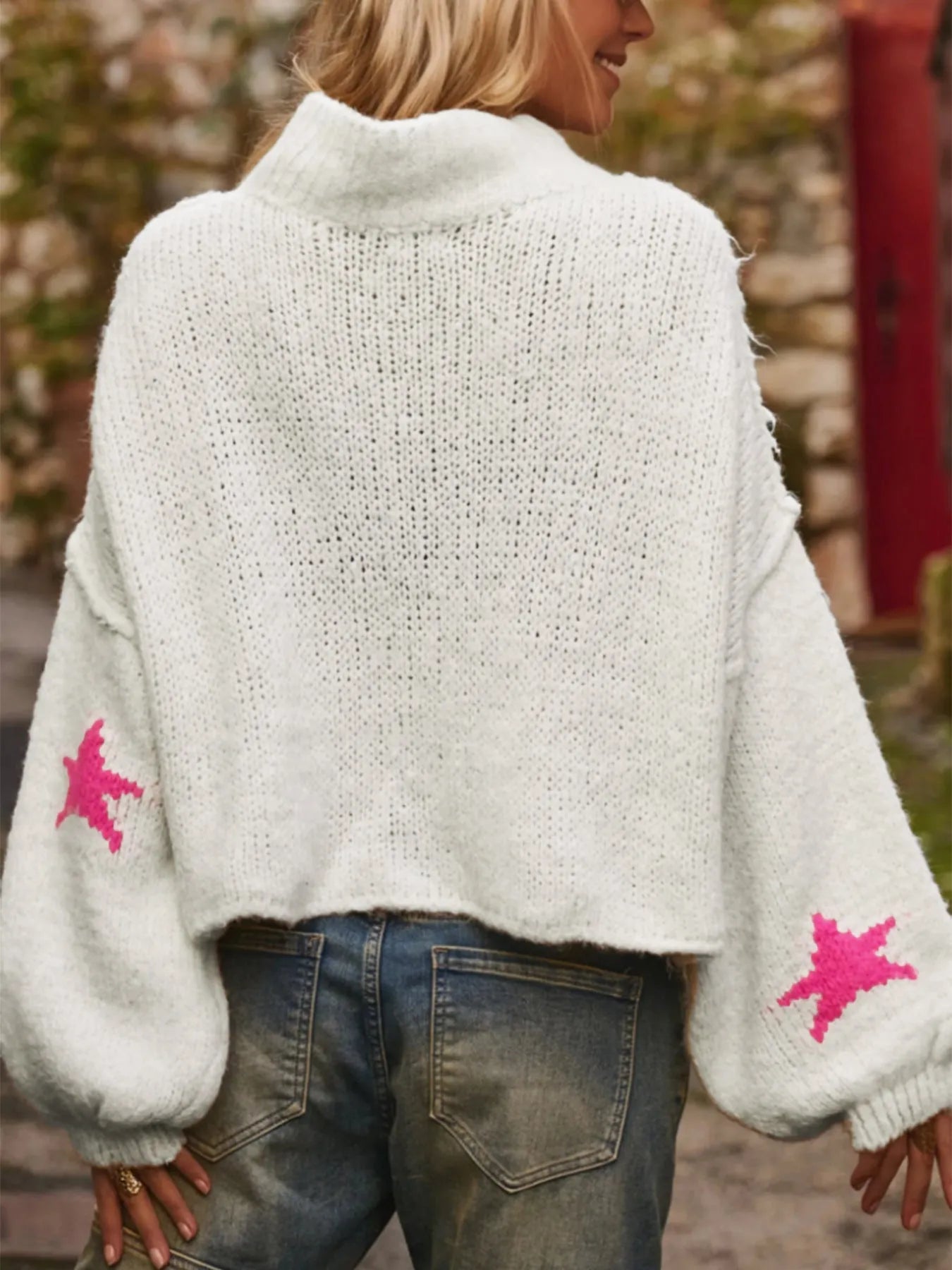 White women's loose fit turtleneck sweater with a black five-pointed star pattern on the front.