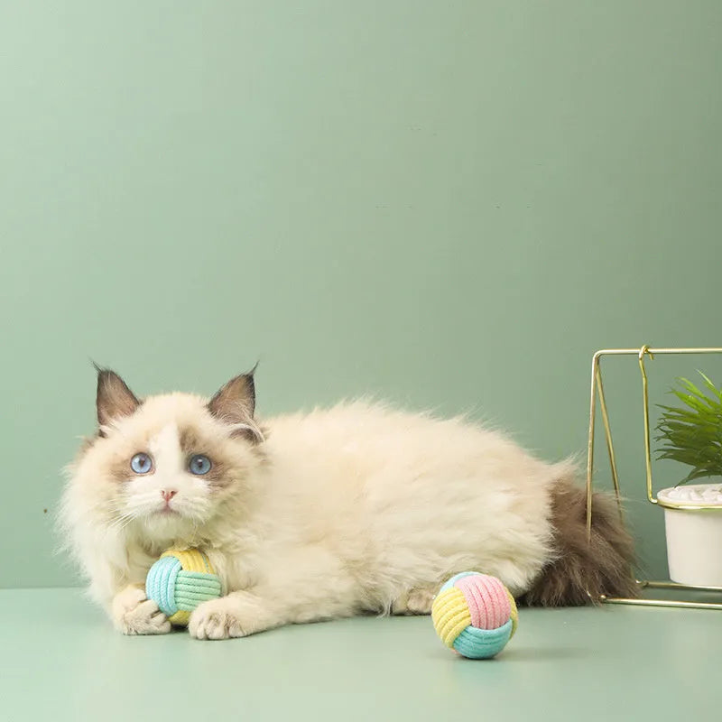 Small handmade cotton plush ball cat toy in blue powder, green blue, or pink green colours, 5cm diameter.