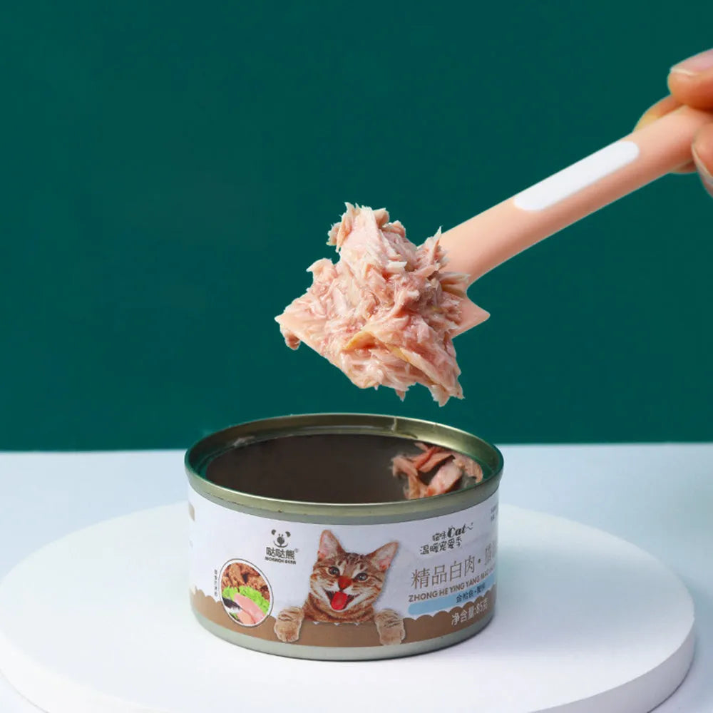 Green long-handled pet feeding spoon for scraping wet food from cans.