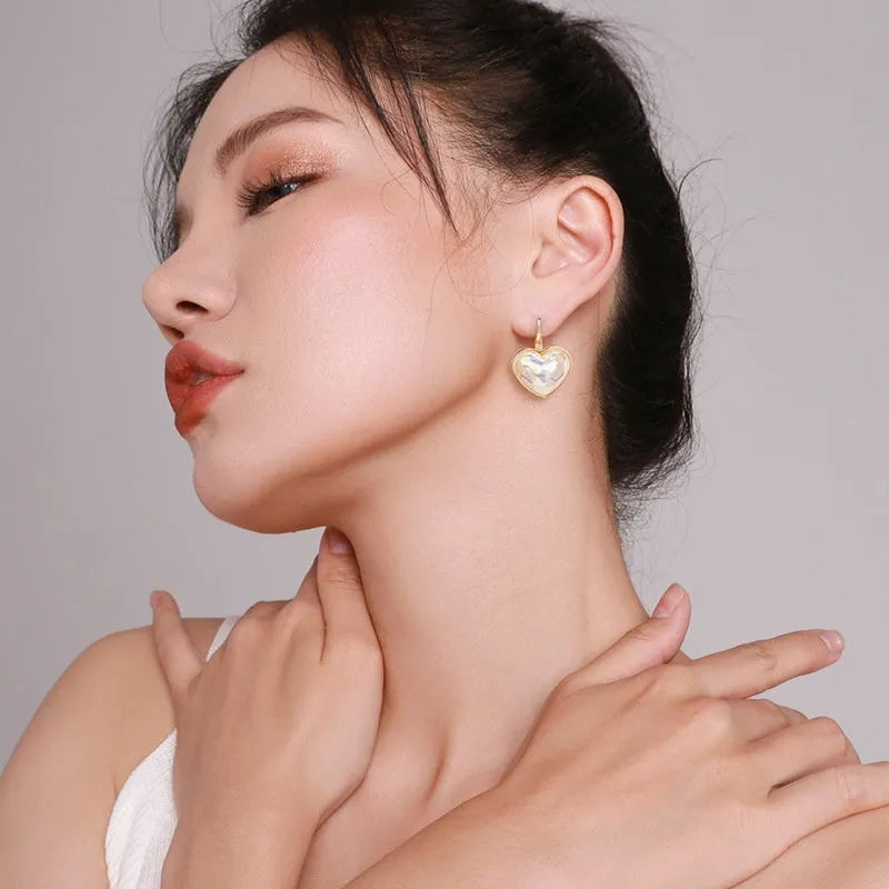 A pair of gold-coloured minimalist alloy ear clip earrings for women on a plain background.