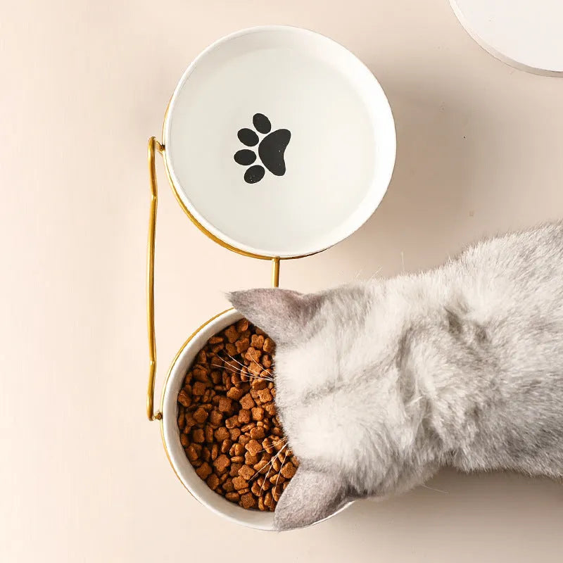 White ceramic cat bowl with cat paw print in a black iron frame stand with cat ears