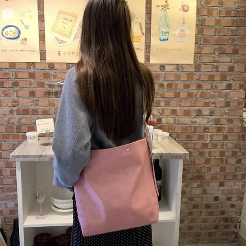 Pink corduroy one-shoulder bag with a single strap, shown next to a brown colour option.