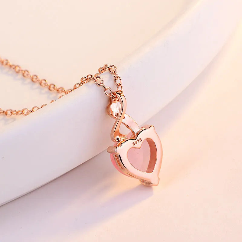 Women's heart-shaped pink synthetic crystal pendant necklace on rose gold cross chain