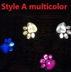 Set of four black animal paw print shaped solar LED garden lights with a central solar panel pole.